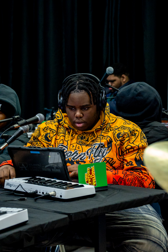 A student producing on a laptop and keyboard controller